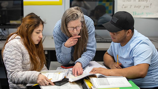 Two students working with a tutor in the Math Resource Center