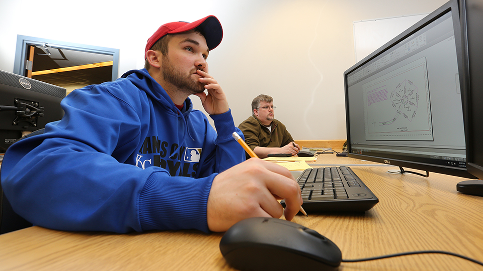 two students practicing AutoCAD on desktop computers