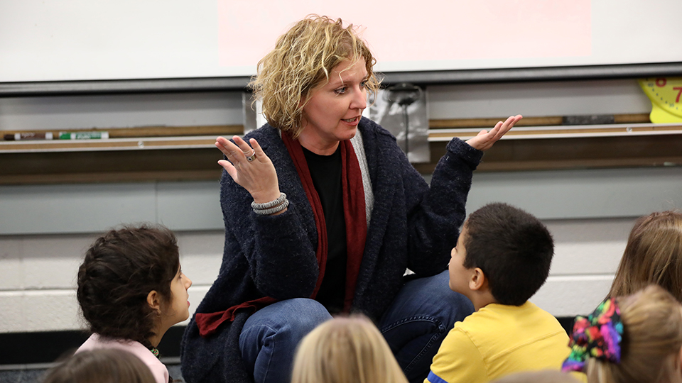 A teacher interacts with a class of young children.