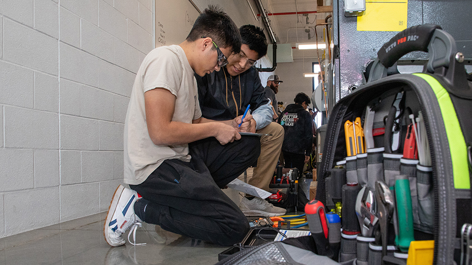 two jccc students working on an HVAC system