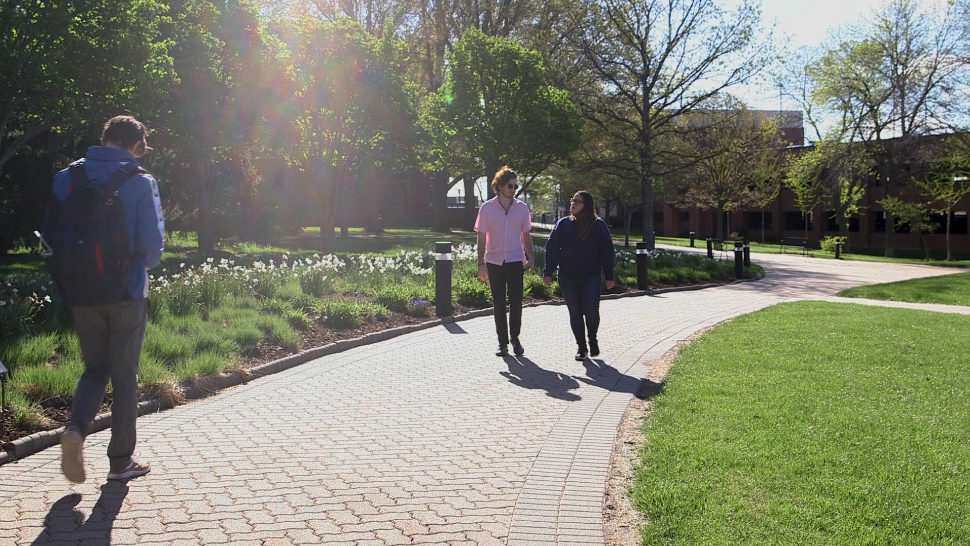 Students walking the path between Galileo's Pavilion and the COM building