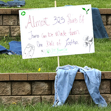 old denim next to a sign that says almost 325 pairs of jeans can be made from one bale of cotton