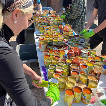 a woman opening expired cans of food