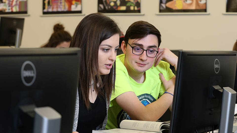 Two students working together on a computer