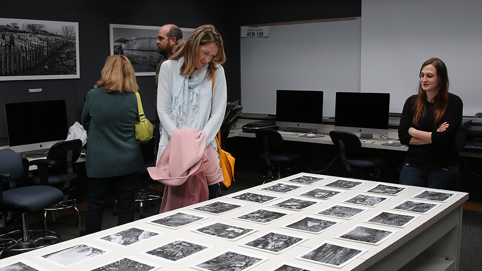 Person examining and exhibit of student photography work